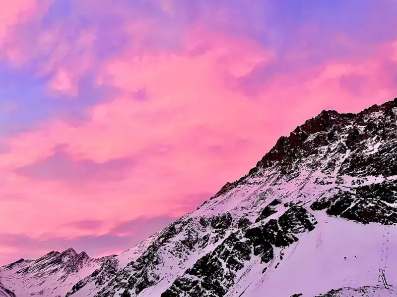 Céu rosa intenso sobre os picos nevados dos Andes, no fim da tarde